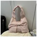 Detail of light pink tote bag with oversized bow design and soft pleated fabric texture - Pink