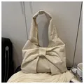Detalle del bolso hobo crema con lazo decorativo grande y textura suave de pliegues - Blanco Roto