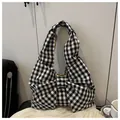 Detalle del bolso hobo con estampado de cuadros vichy negro y blanco y gran lazo frontal - Cuadros Negros