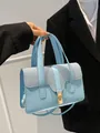 Hellblaue Handtasche aus Kunstleder mit gewebter Klappe und goldener Schnalle - Blau