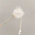 Dettaglio di fermaglio dorato con pompon bianco, strass e nappe eleganti - Stile Orecchie da Gatto