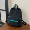 Detail of nylon backpack with turquoise zipper pull and spacious front pocket - Black