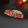 Macro detail of red rhinestone car brooch with gold finish and blue enamel on black fabric - Red Rhinestone Car