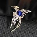 Detalle de broche de fénix elegante con cristal azul y pedrería sobre fondo de seda negra - Fénix Azul
