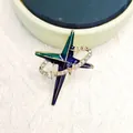 Detalle macro de broche de estrella con esmalte azul-verde y circonitas blancas brillantes - Estilo Planeta con Órbita Esmalte Degradado / Espacio
