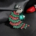 Detalle macro del lujoso broche de pavo real con piedras verdes y cristales de color - Fénix Multicolor Estilo 2