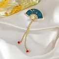 Detalle del broche en forma de abanico con esmalte verde, perla y borlas doradas en seda - Abanico Plegable Borla