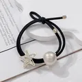 Close-up of double-strand hair tie with sparkling rhinestone starfish and faux pearl - White
