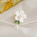 Primer plano de elegante broche de flor con hojas de esmalte y perla colgante en seda - Peonía