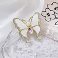 Détail de la broche papillon avec cristal rose, ailes blanches et strass brillants - Rose