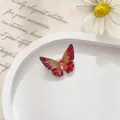 Vista macro detallada del broche de mariposa con alas de esmalte rojo y núcleo de cristal - Pequeño / Rojo