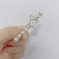 Detalle de una pinza para el pelo con perlas blancas y alas de mariposa de diamantes - Flor Rosa Mariposa