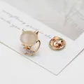 Close-up of golden cat brooch with opal stone and sparkling rhinestones on card - Kitten