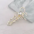 Detalle de una pinza para el pelo plateada estilo lava con gema en forma de corazón - Corazón / Dorado