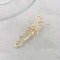 Detalle de pinza para el pelo de mariposa dorada con alas de piedra de luna y brillo - Mariposa / Dorado