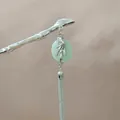 Detalle de horquilla plateada estilo bambú con piedra de jade verde y borlas metálicas largas - Borla de Jade