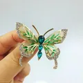 Dettaglio della spilla a farfalla con cristalli verdi e smalto bianco su base dorata - Farfalla a Doppia Faccia (XZ254)