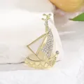 Elegant gold sailboat brooch with white crystals on white stone and floral background - Gold Sailboat