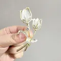 Elegant gold tulip brooch featuring white cat eye stone and sparkling crystals held in hand - White Tulip (XZ42-004)