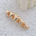 Macro view of five interconnected metallic gold heart hair clips with a polished mirror finish - Gold