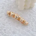 Détail d'une pince à cheveux dorée avec cœurs et texture métallique martelée - Style Cinq Cœurs Martelés / Or