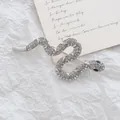 Spilla a forma di serpente argento con strass lucidi e occhi blu su sfondo strutturato - Serpente di Strass Argenteo