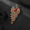 Makroaufnahme der goldenen Pfauenbrosche mit bunten Kristallen und rotem Hauptstein - Prachtvoller Pfau Brosche (Rot)