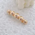 Vue macro détaillée d'une pince à cheveux dorée avec cinq sphères martelées et clip à ressort - Style Cinq Boules Martelées / Or