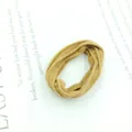 Close-up of brown textured elastic hair tie on a book page with high elasticity detail - Thin Dark Khaki