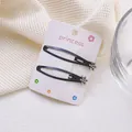 Detalle de dos pinzas BB negras mate con flores de strass sobre cartón de soporte - Estilo de Flor de Cinco Pétalos Mate (3 Clips BB)