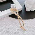 Elegant gold fan-shaped spring hair claw with white pearl detail on knit background - Pearl Twist Hair Clip