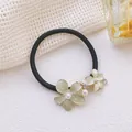Vue détaillée d'un chouchou floral avec des strass et des perles élégantes pour cheveux - Élastique à cheveux translucide à double fleur vert-jaune clair