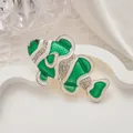 Primer plano de broche de pez en esmalte verde con pedrería sobre fondo blanco - Forma de Pez Payaso / Verde