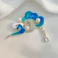 Detalle macro de broche de nube de la suerte en esmalte con perlas sobre seda blanca - Nubes de Buen Augurio Azules (XZ98)