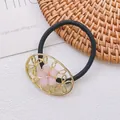 Détail d'un élastique à cheveux en alliage doré avec fleurs roses et strass brillants - Bandeau 11