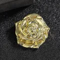 Detailed macro shot of a 3D gold rose brooch with layered petals on a black background - Rose / Gold