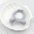 Pale purple bow hair tie made of knitted ribbed fabric on a white shell tray - Blue