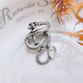 Detailed view of vintage silver snake brooch with intricate scales and black gem eyes - Antique Silver Long Snake Style