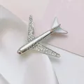 Close-up of a silver airplane brooch with white rhinestones and enamel on silk - Large Silver Airplane Rhinestone Enamel (XZ289)