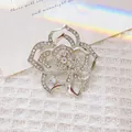 Exquisite silver rose brooch with sparkling rhinestones on elegant white tweed backdrop - Silver