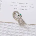 Detalle del broche de serpiente plateado con diamantes de imitación y ojos verdes - Serpiente de Plata con Diamantes Completo