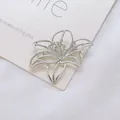 Detailaufnahme der hohlen Lilien-Brosche in Silber mit filigraner Metallverarbeitung - Blumen-Stil / Silber