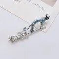 Broche chat sur balai volant en argent avec émail bleu et cristaux étincelants - Chat Argenté avec Balai
