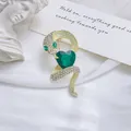 Close-up of vintage gold snake brooch with a large green heart-shaped crystal on white velvet - Gold (XZ315)