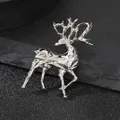 Macro shot of silver geometric faceted elk brooch on a dark textured stone background - Geometric Deer / Silver