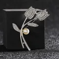 Elegante broche de tulipán plateado con diamantes de imitación y una perla blanca - Perla Plateada