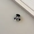 Detail of a black hair claw clip featuring rhinestone bow and pearl tassel accents - Black Rhinestone Bow Tassel Style