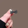 Pinza pequeña para el cabello con lazo de strass negro y acabado metálico brillante - Lazo Solo