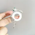 Silver snake brooch with white crystals, green gem eyes and a central white ring detail - Round White Silver (XZ315)