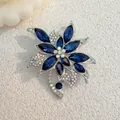 Macro shot of blue crystal flower brooch with rhinestone leaves on matte surface - Deep Blue (XZ99)
